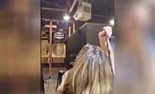 Woman throws knife at target, arm raised mid-throw