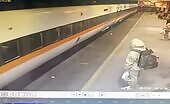 Man walks on platform as train passes close by